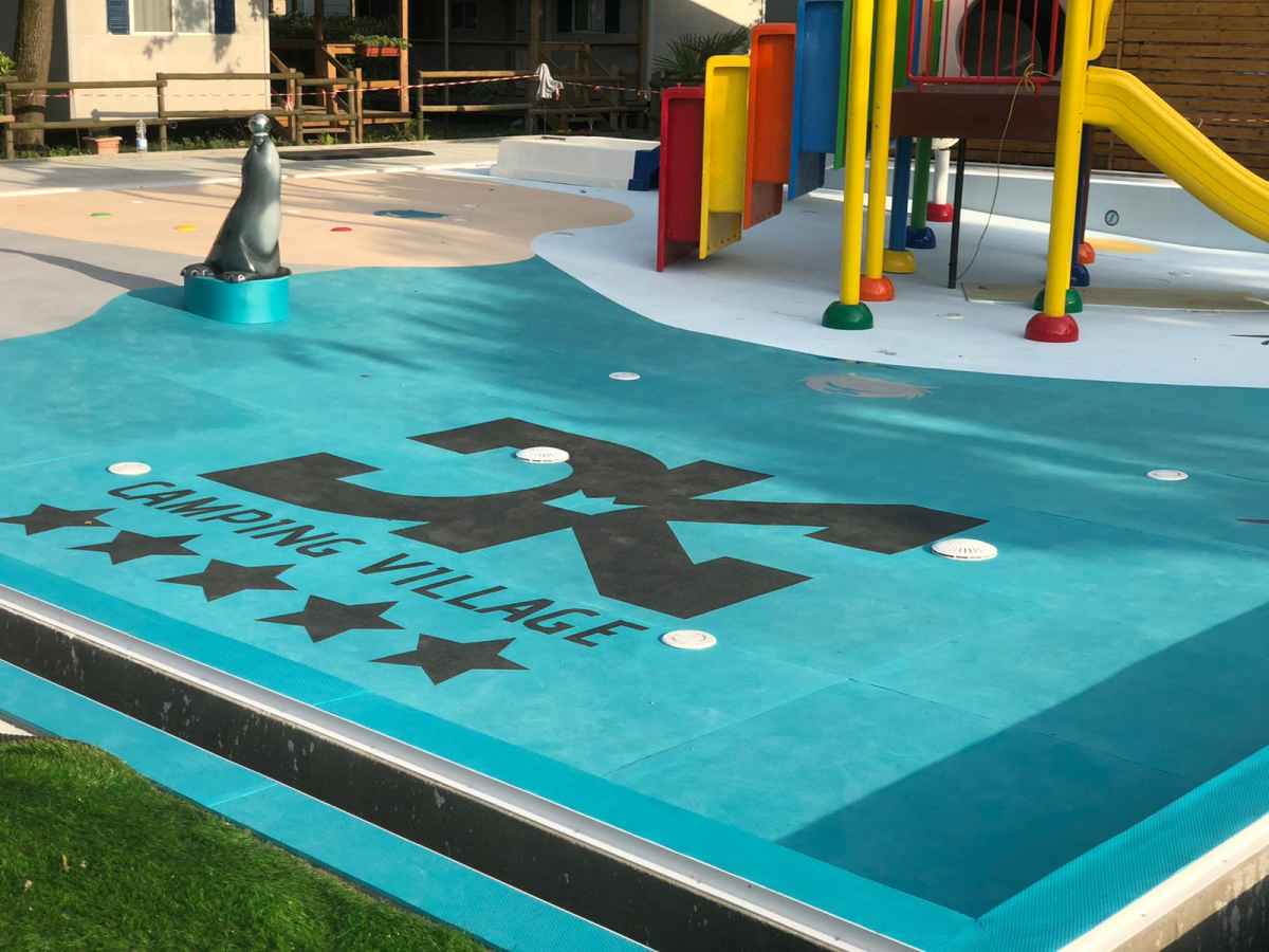 Türkiser SAFEFLOOR-Belag auf einem Wasserspielplatz mit Spielgeräten